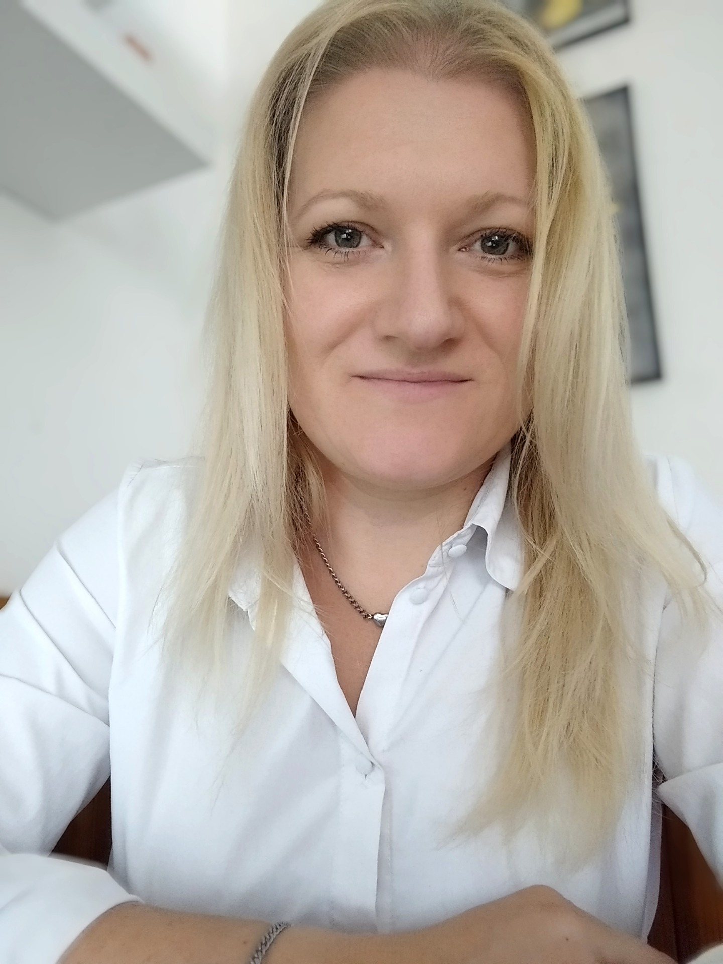 Usměvavá blond žena v bílé košili, záběr zblízka v kancelářském prostředí. Finanční poradkyně Ústí nad Labem, finanční poradce Ústí nad Labem, nezávislý poradce.